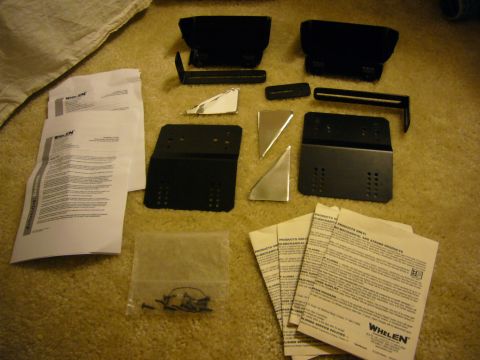 2000 Ford Crown Victoria - Collection of Whelen siren mounting hardware and documentation, including brackets and instruction sheets.