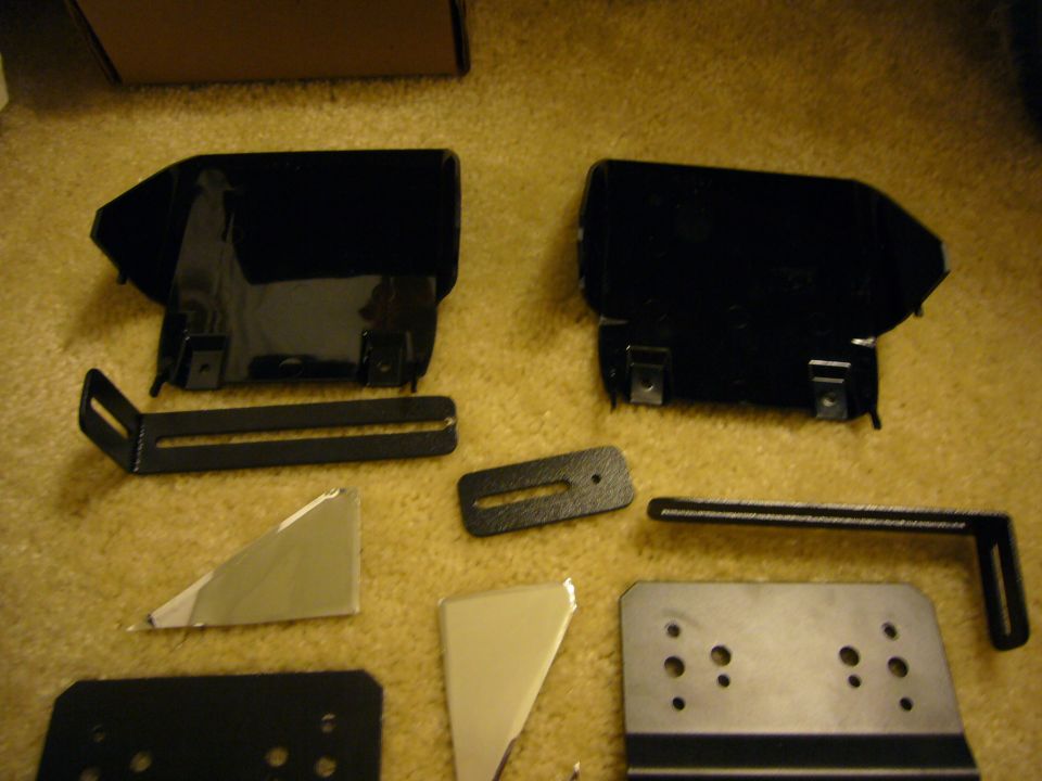 Black metal brackets and plates scattered on carpet