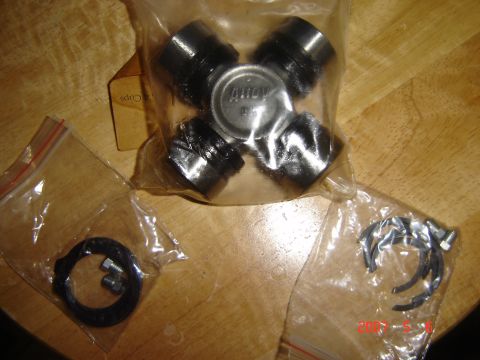 1993 Ford Bronco - A universal joint and associated parts are laid out on a wooden surface.