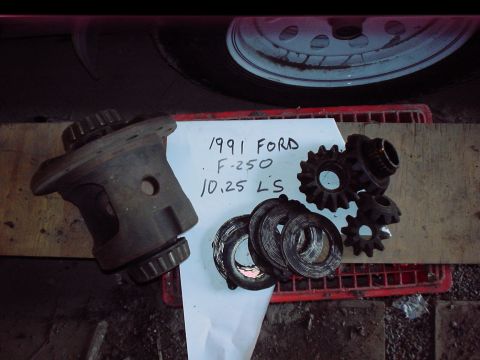 1984 Ford Bronco - A collection of differential gears and components are laid out on a surface with a handwritten label.
