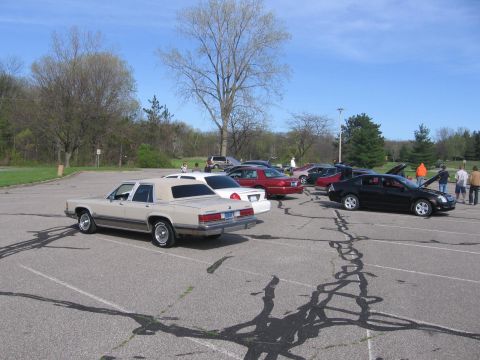 1988 Mercury Grand Marquis - Several cars are parked in an outdoor lot under a bright sky.