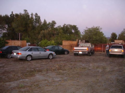 1993 Ford Taurus - A collection of vehicles are parked in an outdoor lot during twilight.