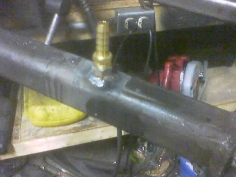 1989 Ford Bronco - A close-up view of a metal tube with a brass fitting, likely part of an air tank setup.