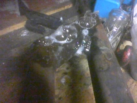 1989 Ford Bronco - A close-up view of a metal component covered in soapy water, suggesting a cleaning or testing process.