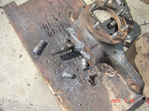 1993 Ford Bronco - This damaged vehicle spindle assembly shows broken studs and appears to be removed from a vehicle.