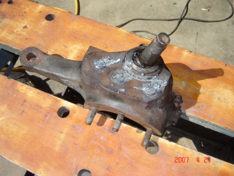 1993 Ford Bronco - A worn steering knuckle, likely from an older vehicle, shows signs of repair with welding.