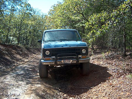 1978 Ford E250 - 1978 Ford E250 4x4 driving on a wooded dirt road.