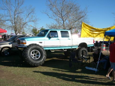 1978 Ford Bronco - A heavily modified pickup truck with large tires is on display at an outdoor event.