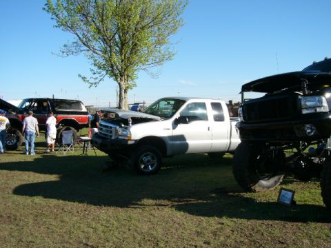 1978 Ford Bronco - A white pickup truck is displayed with its hood open at an outdoor gathering of vehicles.