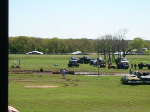 1978 Ford Bronco - A muddy field hosts a gathering of off-road vehicles and spectators, suggesting an event or recreational activity.
