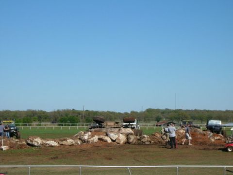 1978 Ford Bronco - Several off-road vehicles are seen maneuvering through a challenging rocky obstacle course under a clear blue sky.