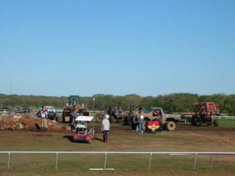 1978 Ford Bronco - A collection of off-road vehicles and a bulldozer are present on a dirt track under a clear blue sky.