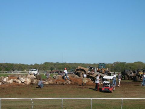 1978 Ford Bronco - Several off-road vehicles are participating in an event on a muddy and rocky terrain.
