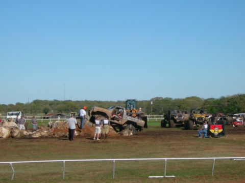 1978 Ford Bronco - Off-road vehicles are stuck in the mud during an event with spectators present.