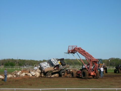 1978 Ford Bronco - A 1978 Ford Bronco is stuck on a pile of rocks while a forklift stands ready to assist.
