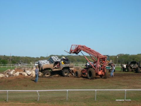 1978 Ford Bronco - A 1978 Ford Bronco is stuck on a rocky incline while a loader attempts to assist.
