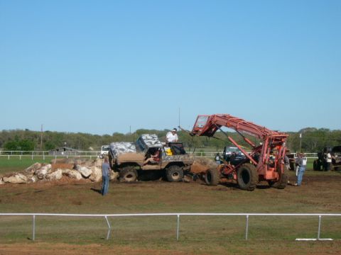 1978 Ford Bronco - A 1978 Ford Bronco attempts to navigate a rocky obstacle with assistance from a tractor loader.