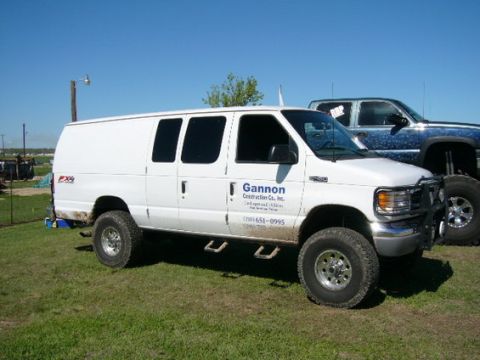 1978 Ford Bronco - White Ford E-Series van with off-road tires and "Gannon Construction Co., Inc." logo.