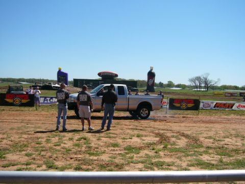 1978 Ford Bronco - A silver pickup truck performs a burnout at an outdoor event, with several track crew members observing the action.