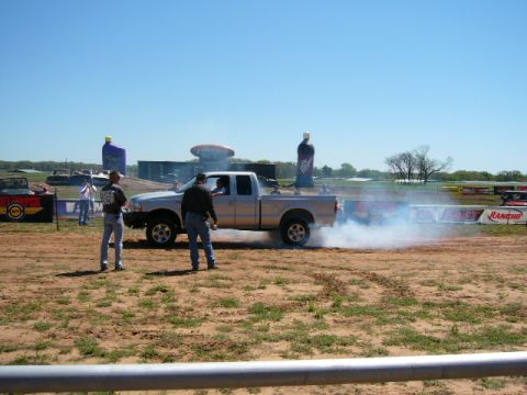 1978 Ford Bronco - Pickup truck performing a burnout at an outdoor event with spectators.