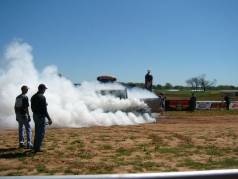 1978 Ford Bronco - A truck performs a burnout, generating a large cloud of smoke on a sunny day at an outdoor event.