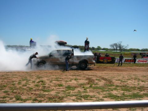 1978 Ford Bronco - A tan Ford F-Series truck is seen performing a burnout with two men nearby.