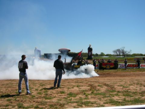 1978 Ford Bronco - A vehicle performs a burnout, creating a large cloud of smoke, as spectators observe.