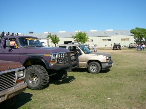 1978 Ford Bronco - Purple lifted 1970s Ford pickup with flame graphics on the roof, a roof-mounted light bar, black fender flares and chrome wheels on tall mu…