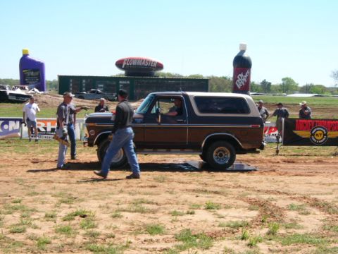 1978 Ford Bronco - A classic Ford Bronco is the center of attention at an outdoor event with large inflatable advertisements in the background.