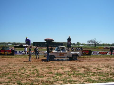 1978 Ford Bronco - A white 1978 Ford F-150 pickup truck is performing a burnout on a dirt track under a clear blue sky.