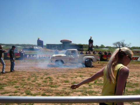 1978 Ford Bronco - A pickup truck performs a burnout, creating a cloud of smoke during an outdoor event.