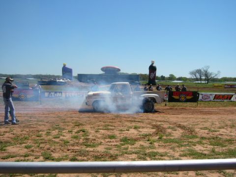 1978 Ford Bronco - A pickup truck performs a burnout, kicking up smoke, with spectators watching in the background.