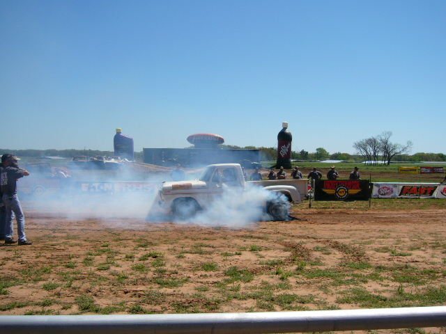 White 1978 pickup truck doing a burnout, emitting thick smoke