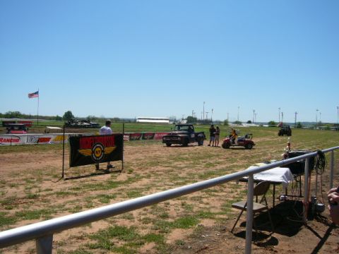1978 Ford Bronco - An outdoor event with a vintage pickup truck and golf carts on a dirt field under a clear blue sky.