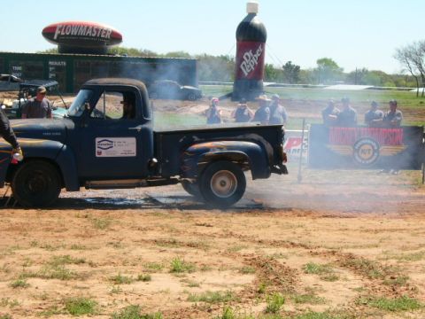 1978 Ford Bronco - A blue 1956 Ford F-100 pickup truck is doing a burnout at an outdoor event.