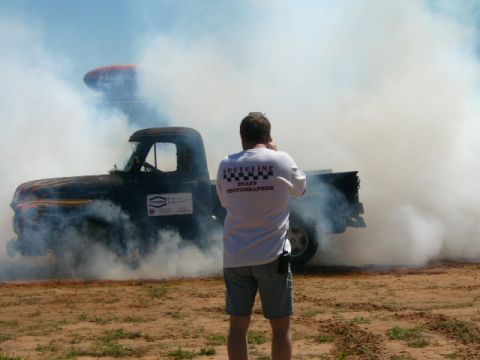 1978 Ford Bronco - A vintage pickup truck performs a burnout, enveloped in a cloud of smoke, while a photographer captures the moment.