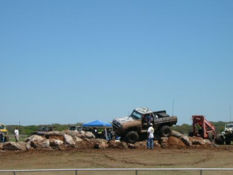 1978 Ford Bronco - A muddy 1978 Ford Bronco navigates a rocky obstacle course during a competition.
