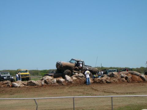 1978 Ford Bronco - A muddy 1977 Ford F-150 navigates a rocky obstacle course, with other off-road vehicles present.