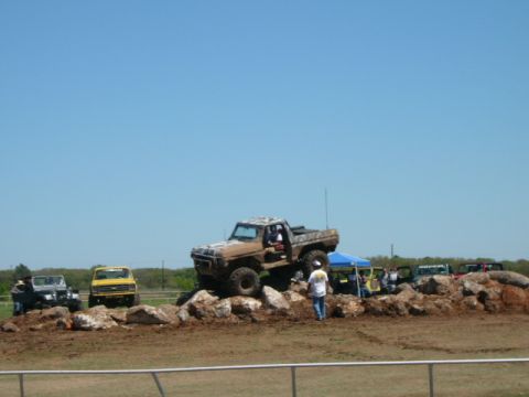 1978 Ford Bronco - A 1978 Ford Bronco navigates a rocky obstacle course with other vehicles in the background.
