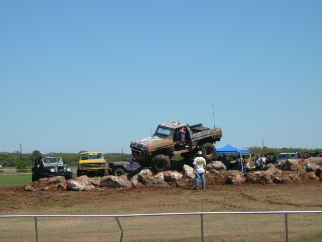 1978 Ford Bronco climbing rocks, with other off-road vehicles nearby
