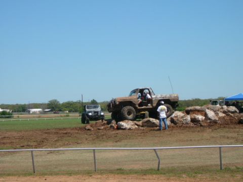1978 Ford Bronco - Two off-road vehicles, a Ford Bronco and a Jeep, tackle a challenging rock obstacle.