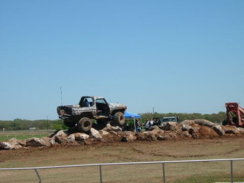 1978 Ford Bronco - A camouflaged 1978 Ford Bronco navigates a rocky obstacle course under a clear blue sky.