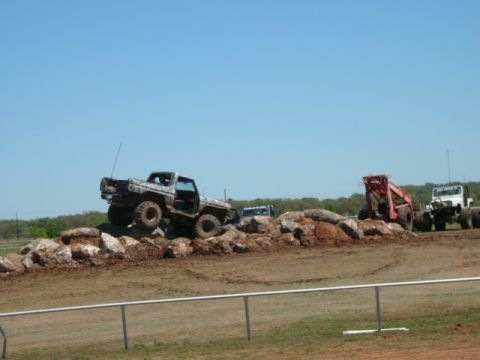 1978 Ford Bronco - A modified off-road vehicle navigates a rocky obstacle course under a clear blue sky.