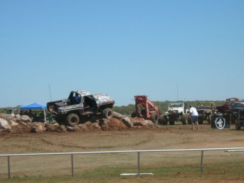 1978 Ford Bronco - Multiple off-road vehicles participate in an event, with one Ford Bronco navigating a rocky obstacle.