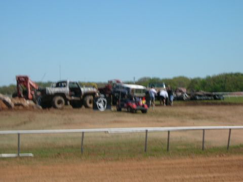 1978 Ford Bronco - Multiple vehicles and people are gathered in an open field under a clear blue sky.