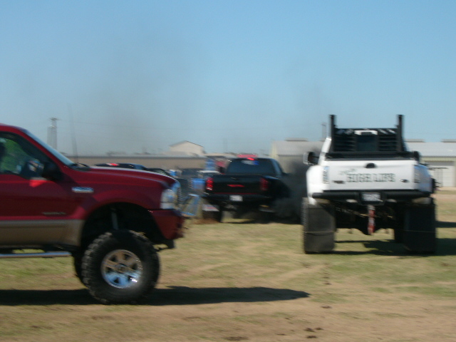 Red truck in foreground, white truck with "EDGE LIFE" text in background