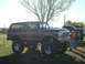1978 Ford Bronco - Very small, low-resolution photo of a dark lifted truck or SUV parked on grass, viewed from the front three-quarter. Detail is too coarse t…