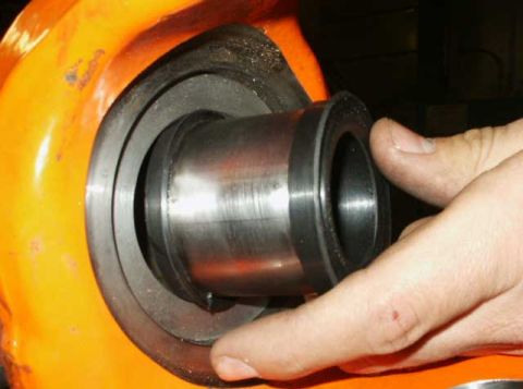 1991 Ford Bronco - A close-up shows a hand carefully inserting a part into a larger component.