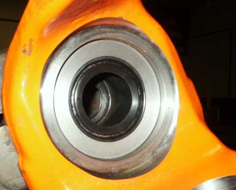 1991 Ford Bronco - Close-up view of an orange painted metal component with a visible bearing assembly.