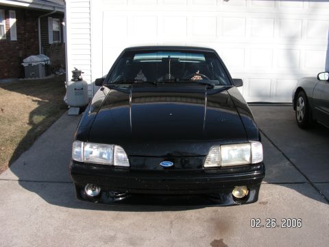 1988 Ford Mustang - Front view of a black 1988 Ford Mustang parked in front of a garage door.